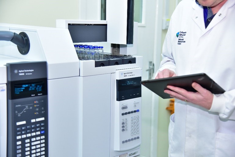 person in white coat analysing in NRW laboratory