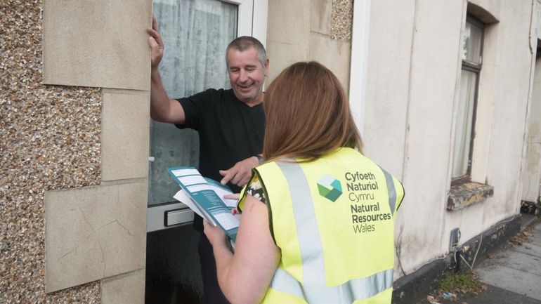 NRW staff member explaining a flood plan to a member of the public